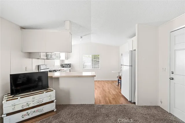 a kitchen with wooden floors and appliances