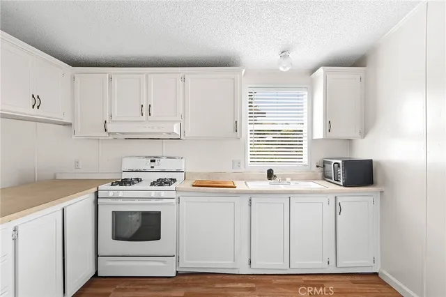 a kitchen with stainless steel appliances granite countertop a sink and a stove