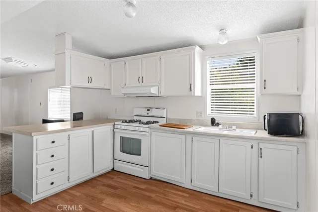 a kitchen with white cabinets and white appliances