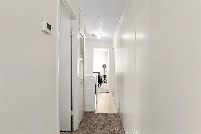 a view of a hallway with bathroom and shower