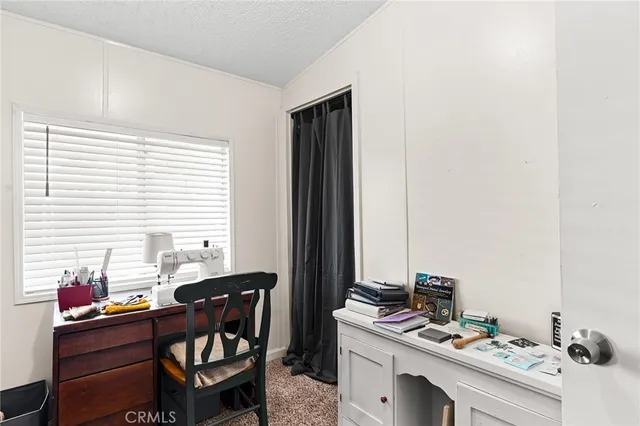 a view of a workspace with furniture and a window
