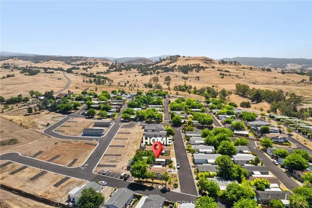 an aerial view of a house with a yard and large tree