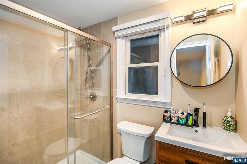 260 Kensington Road River Edge, NJ 07661 - Photo 16 of 22 a bathroom with a sink a mirror a toilet and a shower