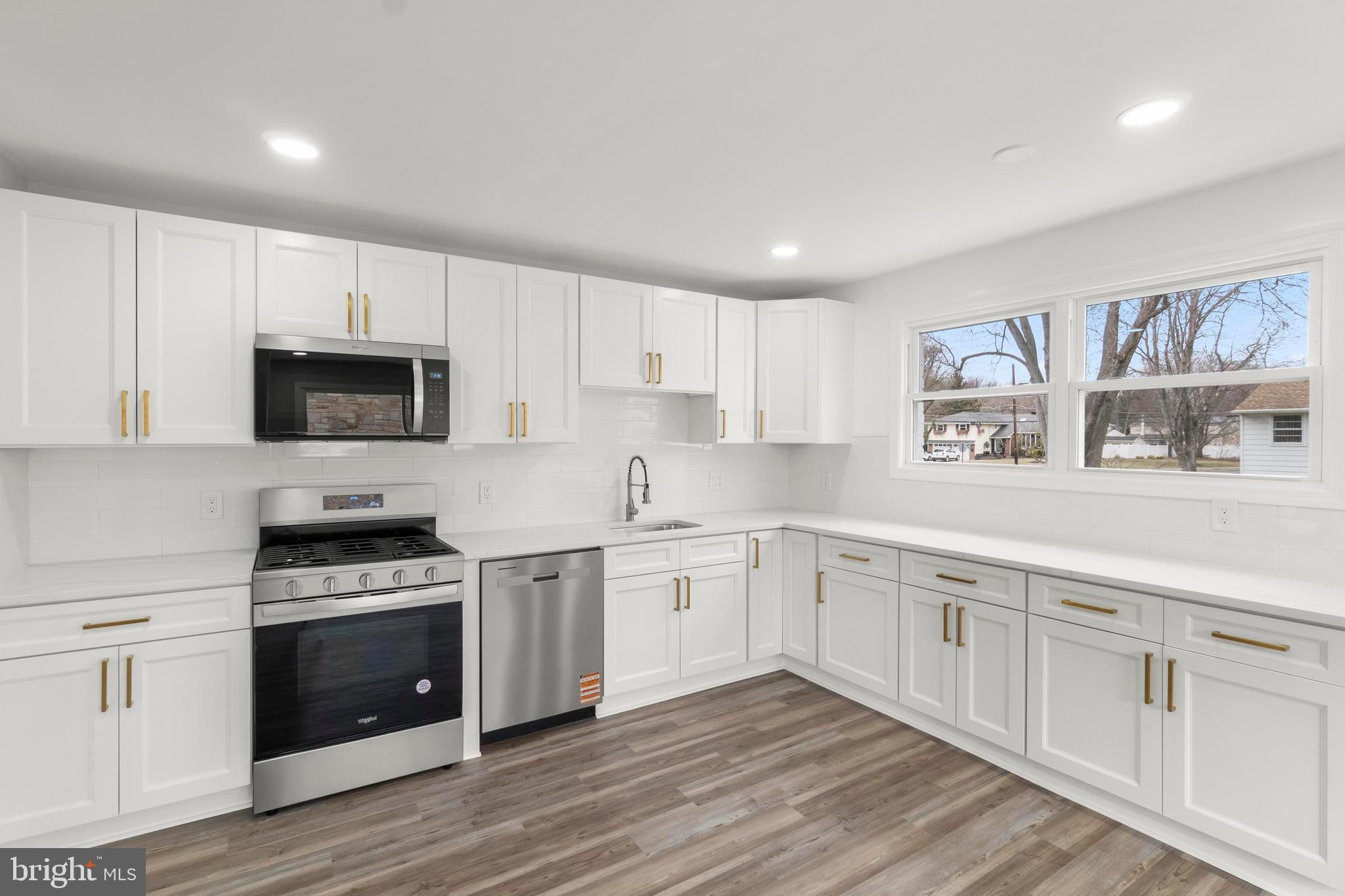 998 Kingston Drive Cherry Hill, NJ 08034 - Photo 17 of 35 a kitchen with granite countertop white cabinets and stainless steel appliances