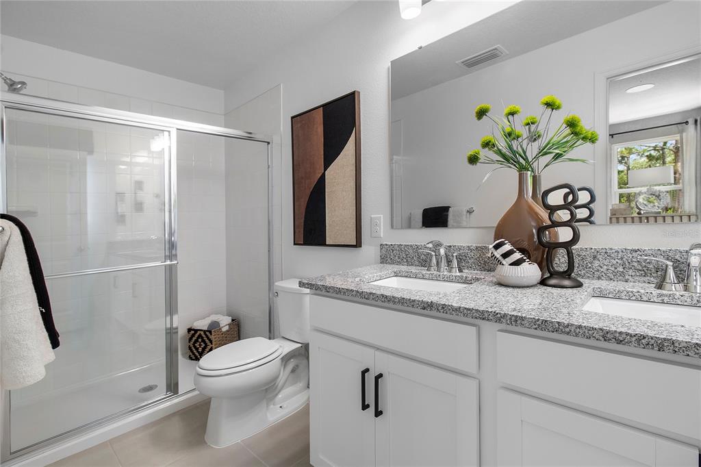 16639 Luminary Loop Clermont, FL 34714 - Photo 23 of 26 a bathroom with a granite countertop sink a toilet and a mirror
