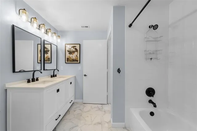 a bathroom with a tub sink and mirror