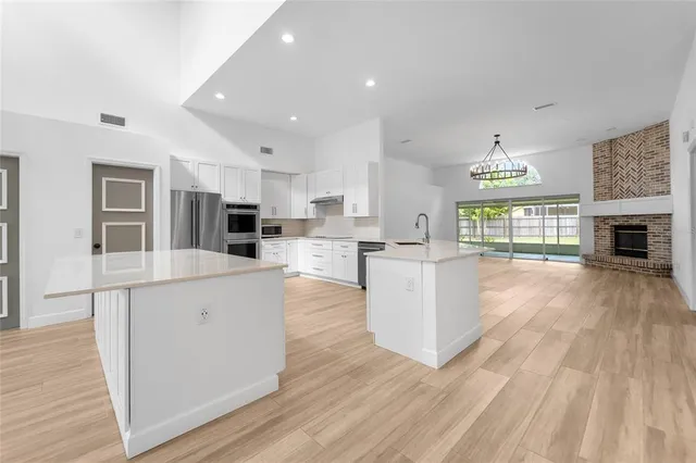 a large kitchen with cabinets wooden floor and a fireplace