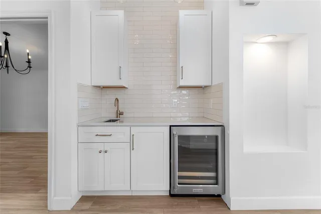 a kitchen with white cabinets and sink