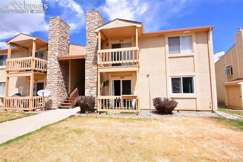 846 Tenderfoot Hill Road, Unit 104 Colorado Springs, CO 80906 - Photo 1 of 13 a front view of a house with a yard