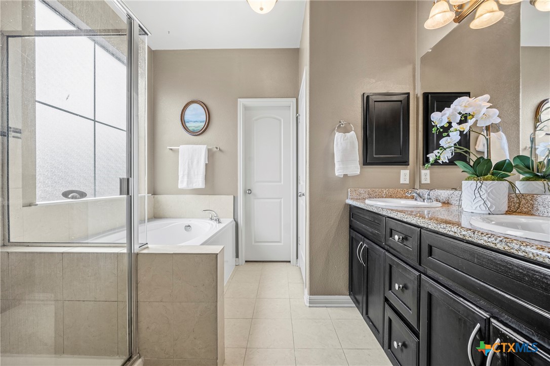 3306 Castleton Drive Killeen, TX 76542 - Photo 12 of 39 a spacious bathroom with a granite countertop sink a mirror and a shower