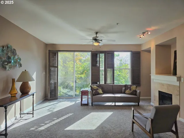 a living room with furniture a fireplace and a floor to ceiling window