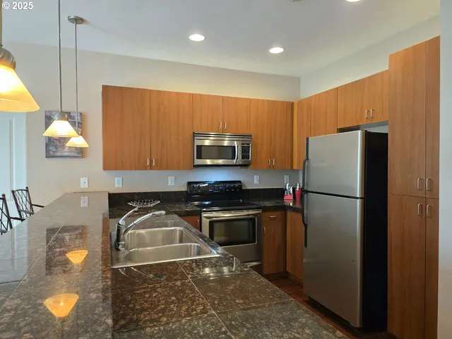 a kitchen with a refrigerator and a stove top oven