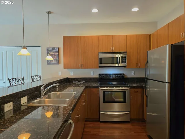 a kitchen that has a sink stainless steel appliances and cabinets
