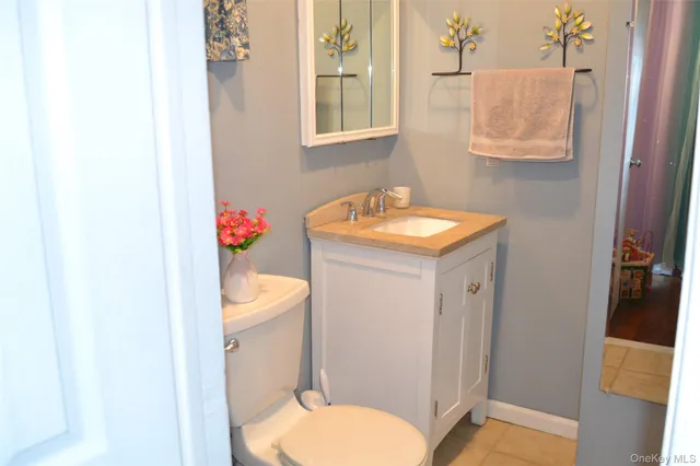a bathroom with a granite countertop toilet sink and mirror
