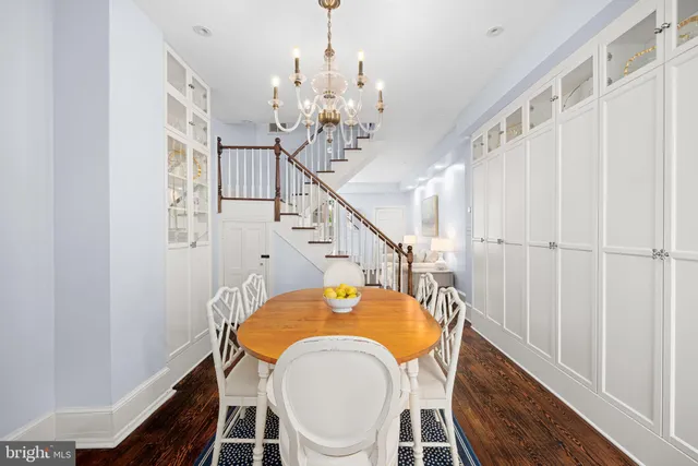 a dining room with furniture a chandelier and wooden floor