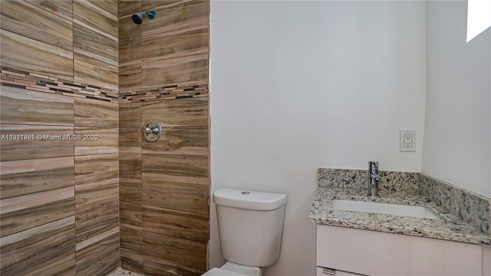 Brownsville Miami, FL 33142 - Photo 9 of 12 a bathroom with a granite countertop sink toilet and shower