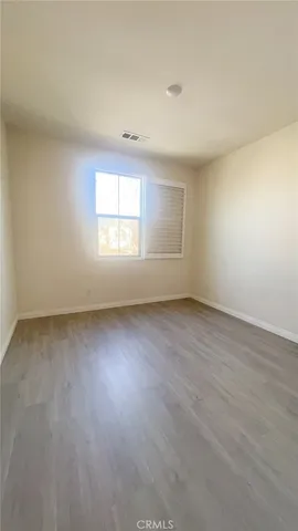 an empty room with a window and refrigerator