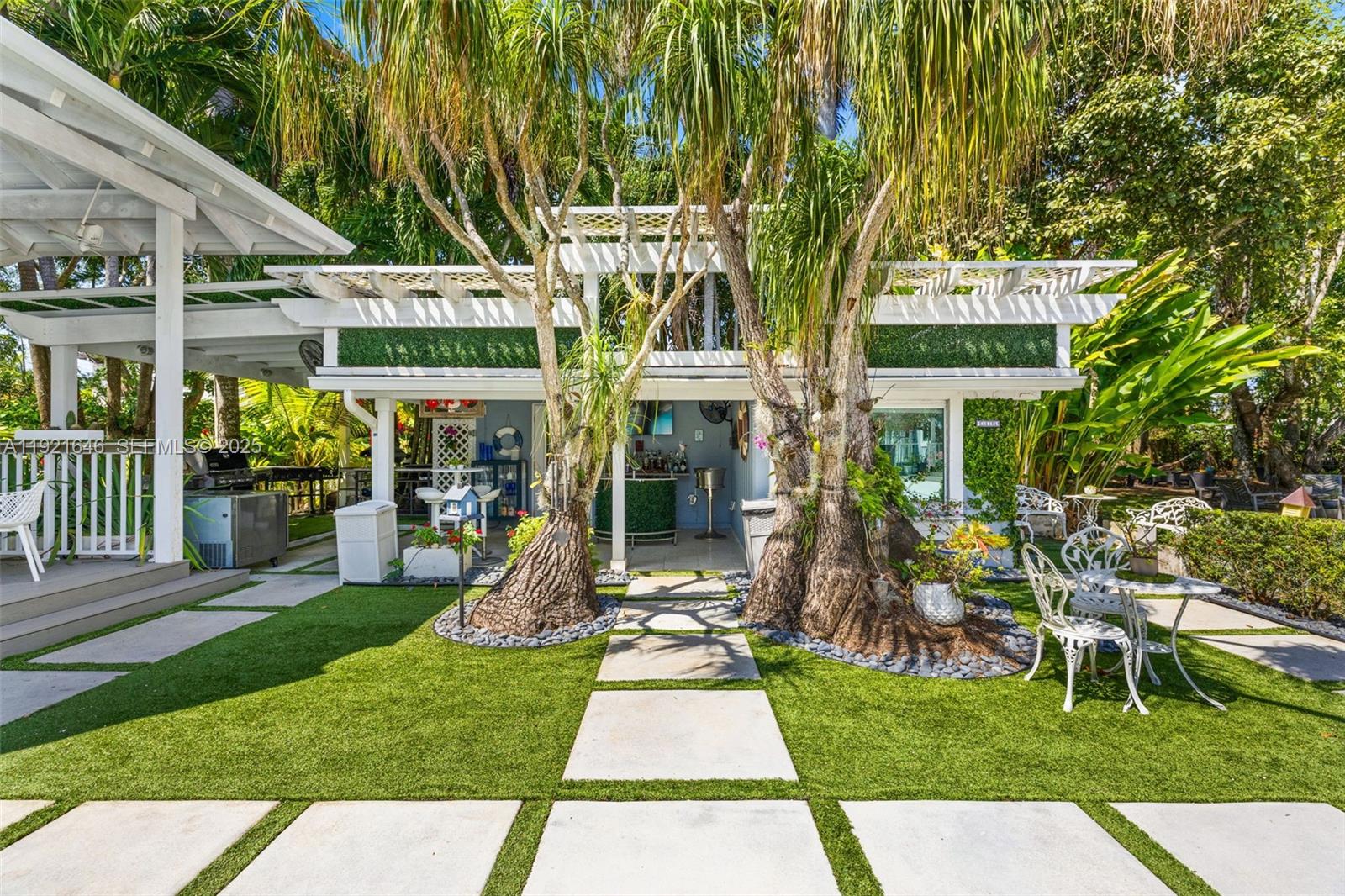 7720 Southwest 79th Court Miami, FL 33143 - Photo 16 of 58 a front view of a house with a yard table and chairs
