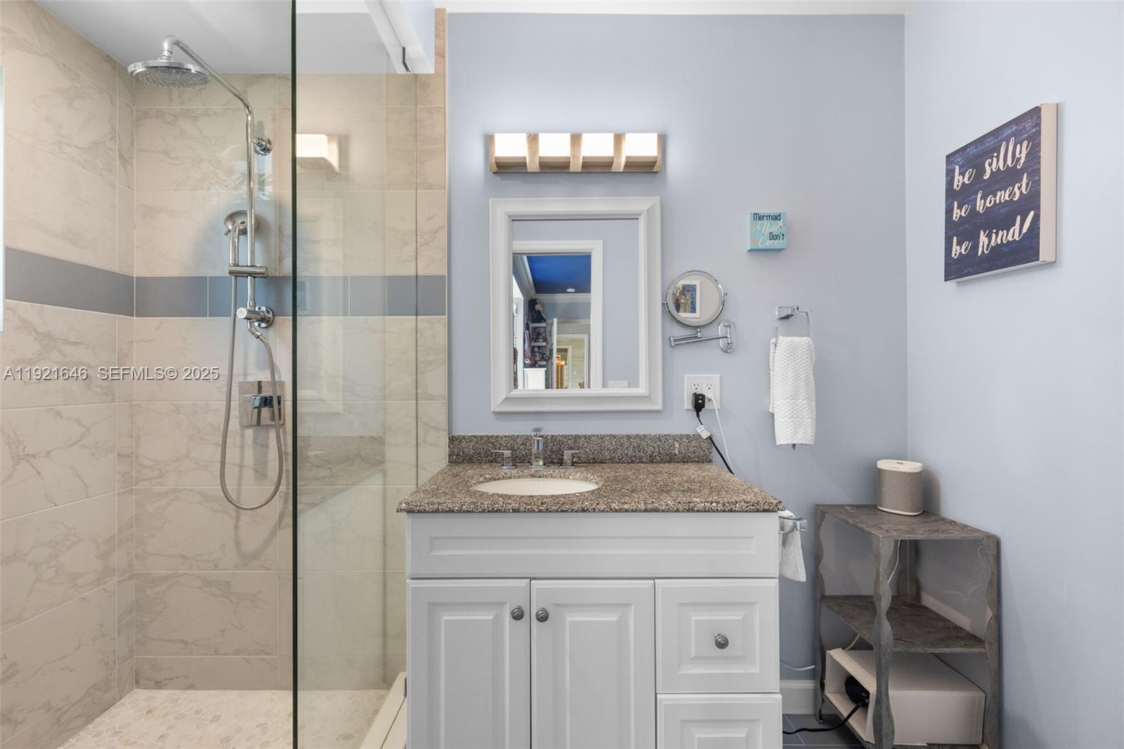 7720 Southwest 79th Court Miami, FL 33143 - Photo 42 of 58 a bathroom with a granite countertop sink a mirror and shower
