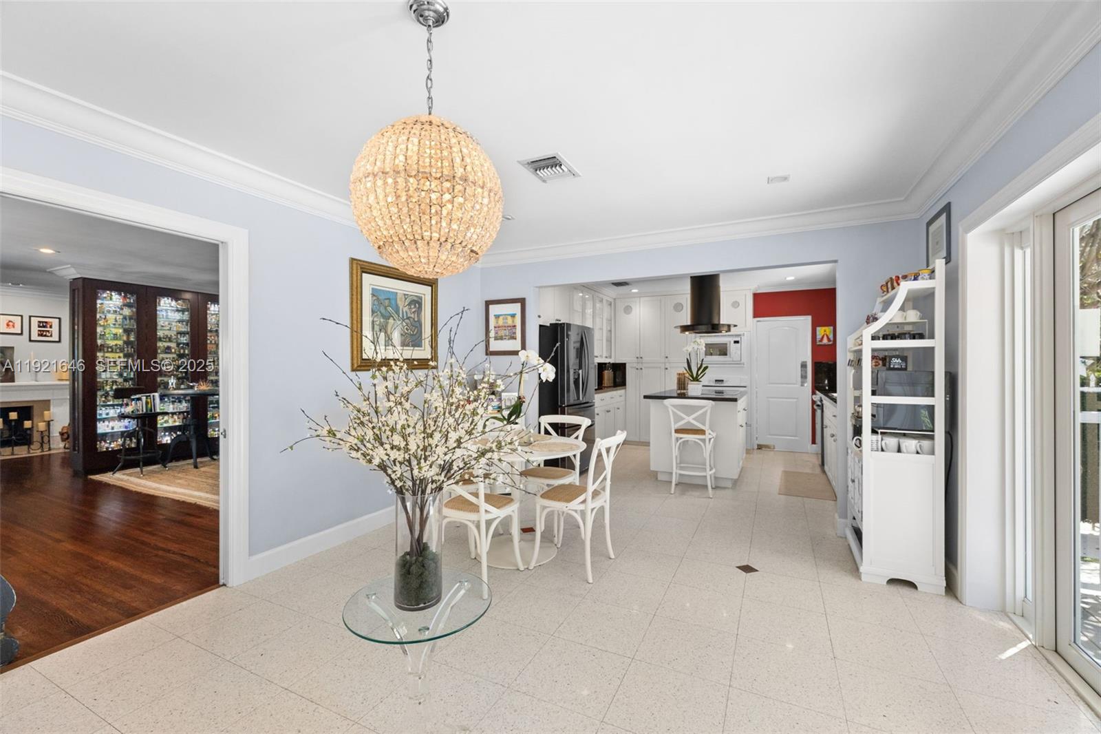 7720 Southwest 79th Court Miami, FL 33143 - Photo 48 of 58 a dining room with wooden floor a chandelier a glass table and chairs