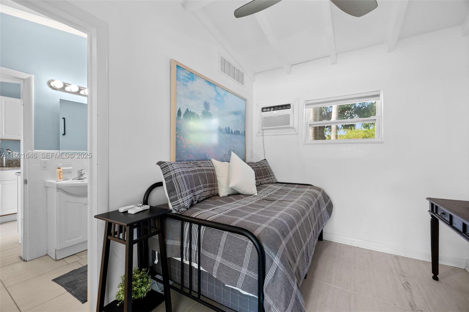 7720 Southwest 79th Court Miami, FL 33143 - Photo 55 of 58 a bedroom with a bed and wooden floor