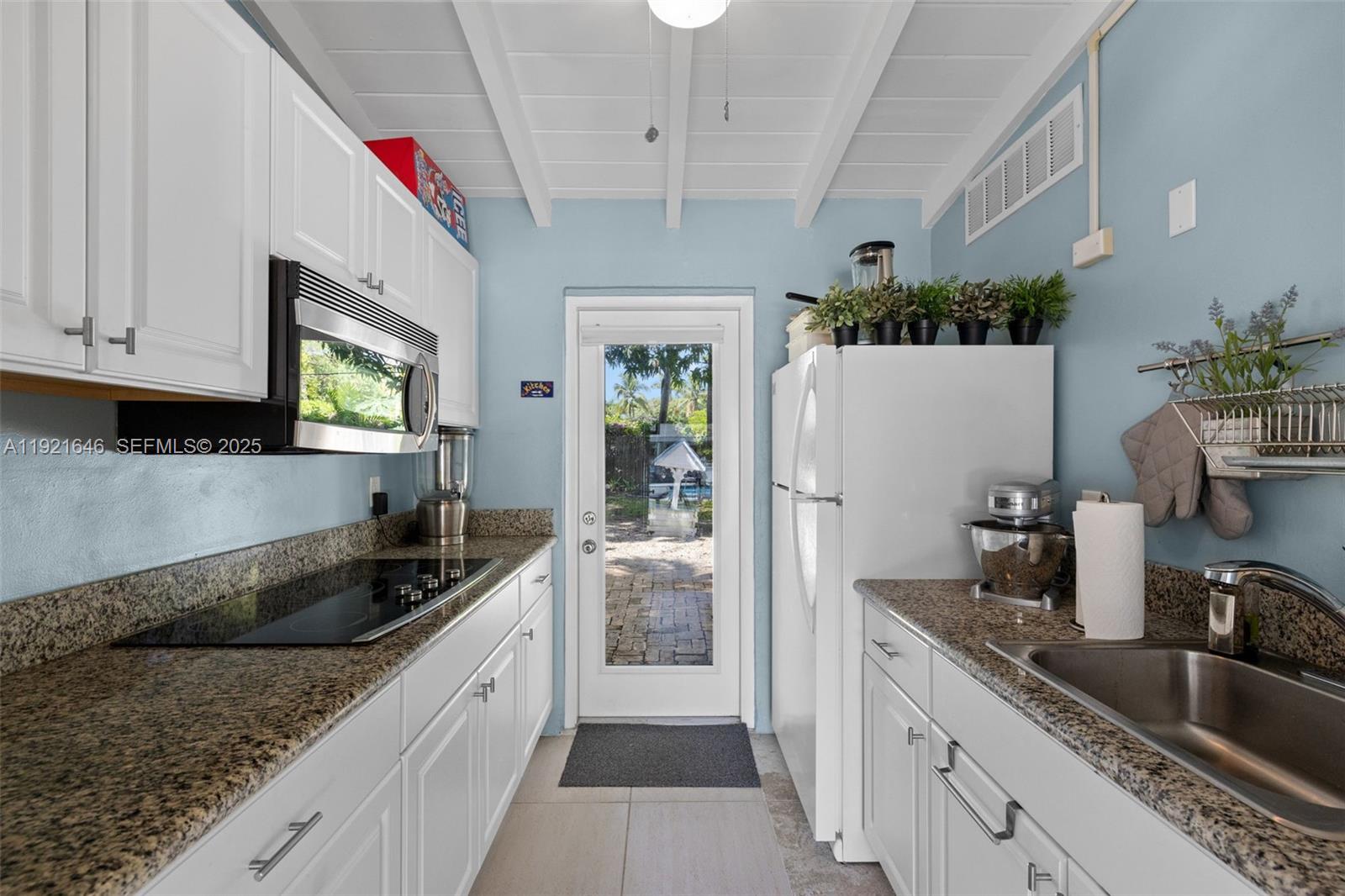 7720 Southwest 79th Court Miami, FL 33143 - Photo 57 of 58 a kitchen with granite countertop a sink stainless steel appliances a counter space and cabinets