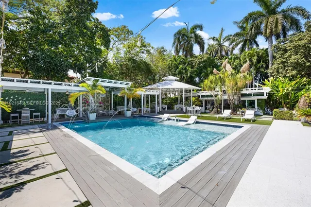 a view of a swimming pool with a patio and a yard