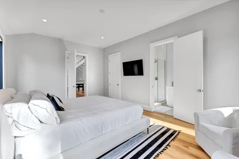 a spacious bathroom with a double vanity sink toilet mirror and shower
