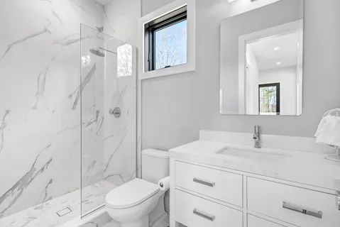 a bathroom with a sink a toilet and shower