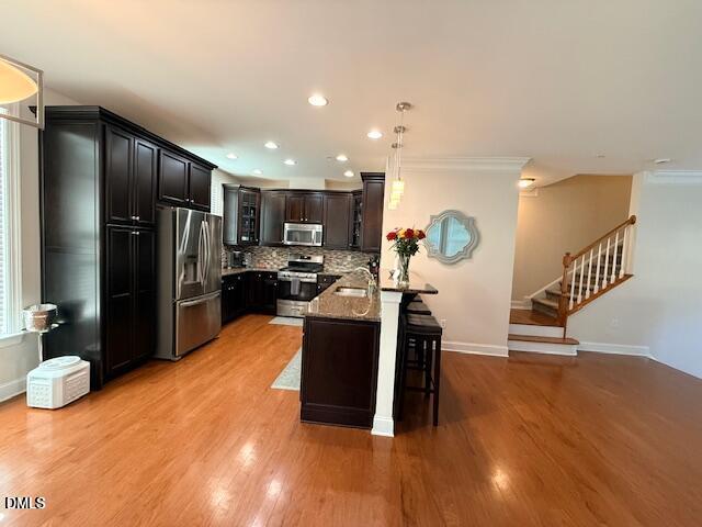 10510 Sablewood Drive, Unit 116 Raleigh, NC 27617 - Photo 14 of 47 a kitchen with stainless steel appliances kitchen island granite countertop a refrigerator a stove a sink and a dining table with wooden floor