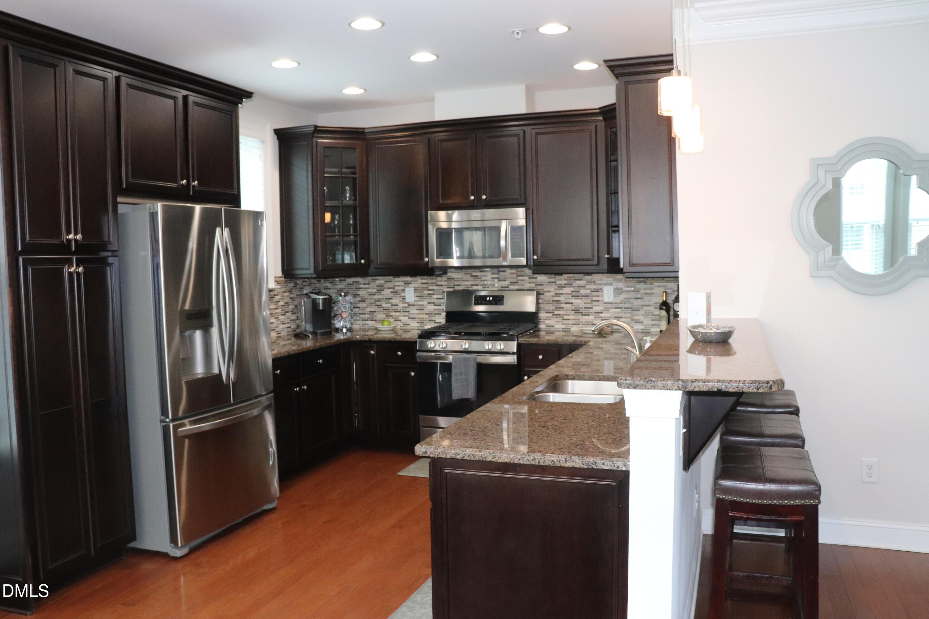 10510 Sablewood Drive, Unit 116 Raleigh, NC 27617 - Photo 16 of 47 a kitchen with kitchen island granite countertop stainless steel appliances and refrigerator