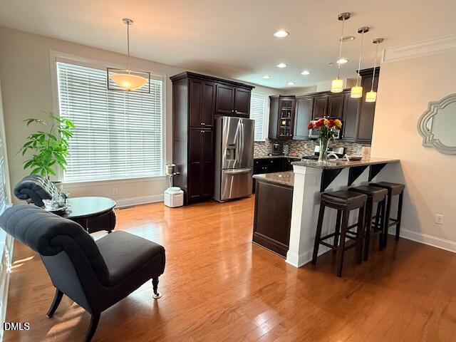 10510 Sablewood Drive, Unit 116 Raleigh, NC 27617 - Photo 17 of 47 a kitchen with stainless steel appliances kitchen island granite countertop a refrigerator a stove a sink a dining table and chairs with wooden floor