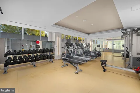 a living room with furniture gym equipment and a large window