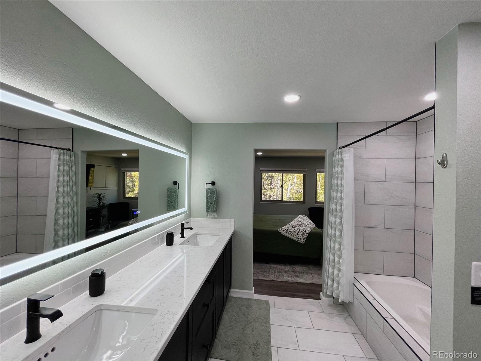 265 Caesar Road Black Hawk, CO 80422 - Photo 27 of 42 a en suite bathroom with a tub sink and mirror