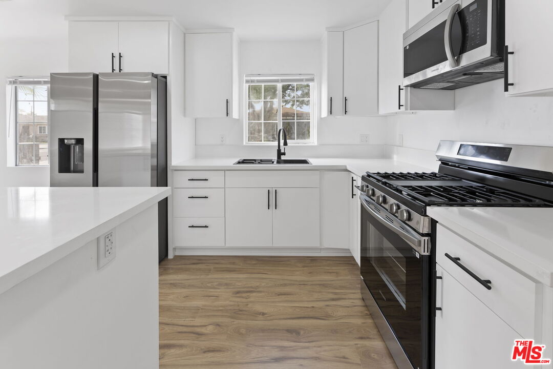 6833 Crafton Avenue Bell, CA 90201 - Photo 16 of 33 a kitchen with stainless steel appliances granite countertop a stove a sink and a refrigerator