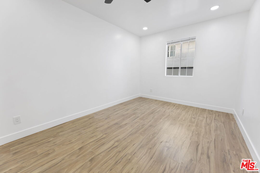 6833 Crafton Avenue Bell, CA 90201 - Photo 27 of 33 an empty room with wooden floor and windows