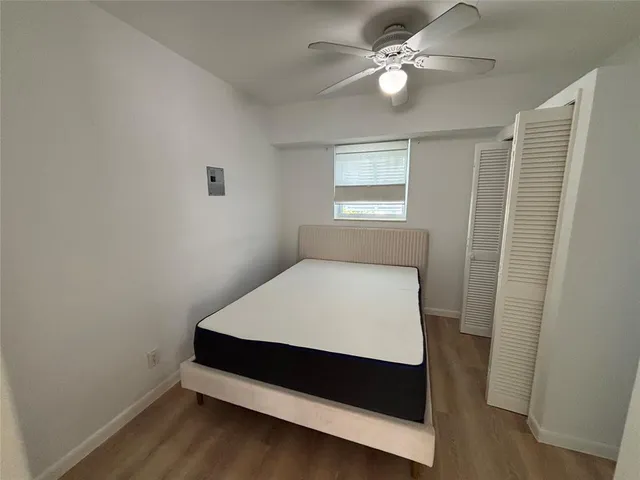 a bedroom with a bed and a ceiling fan