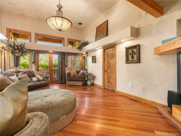 a living room with furniture chandelier and wooden floor