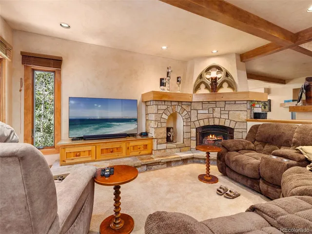 a living room with furniture a flat screen tv and a fireplace