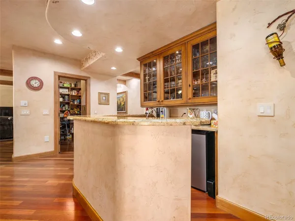 a view of a kitchen with furniture and wooden floor