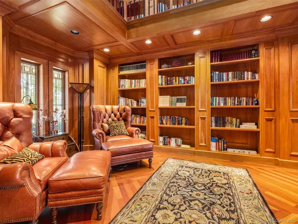 a living room with furniture a rug and a bookshelf
