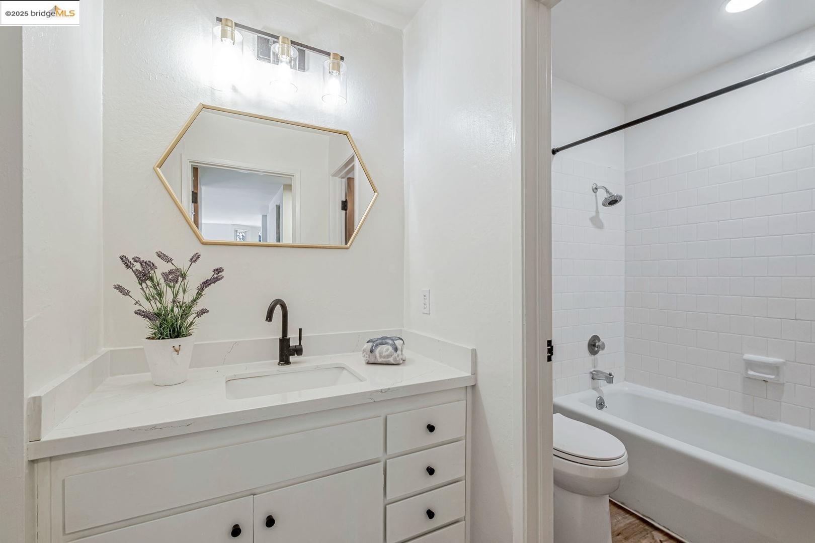 2700 Le Conte Avenue, Unit 301 Berkeley, CA 94709 - Photo 15 of 22 a bathroom with a toilet a sink a tub a mirror and vanity