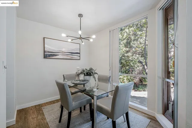 a dining room with furniture a chandelier and wooden floor