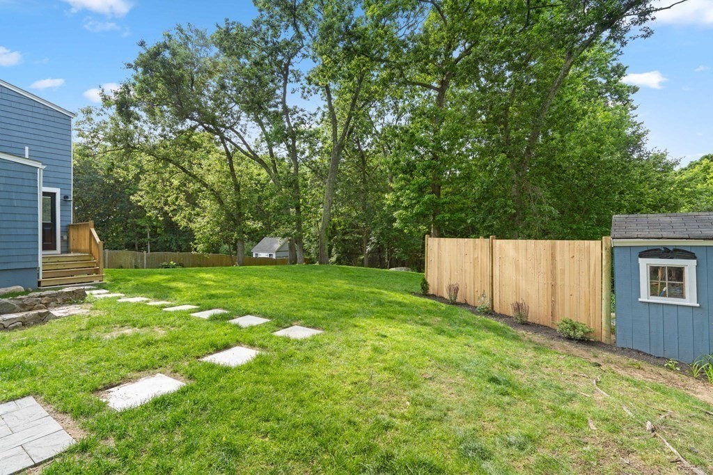 19 Cold Spring Road, Unit S North Reading, MA 01864 - Photo 27 of 30 a backyard of a house with lots of plants and large tree
