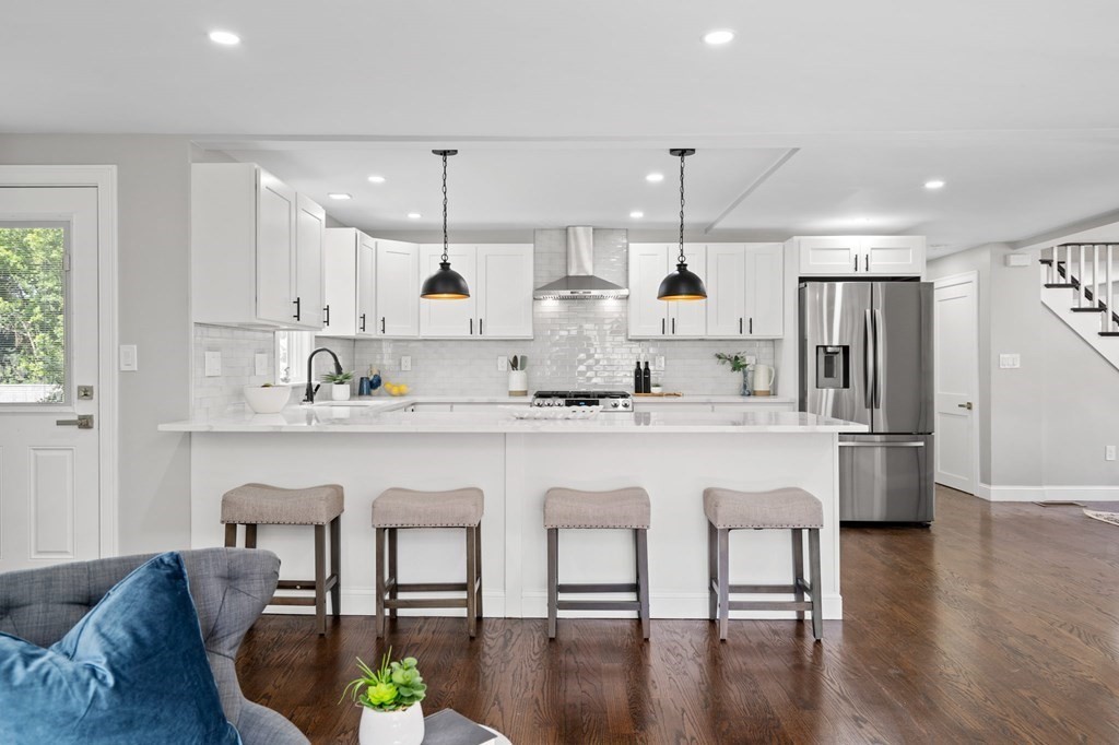 19 Cold Spring Road, Unit S North Reading, MA 01864 - Photo 8 of 30 a kitchen with stainless steel appliances granite countertop a table chairs sink refrigerator and microwave