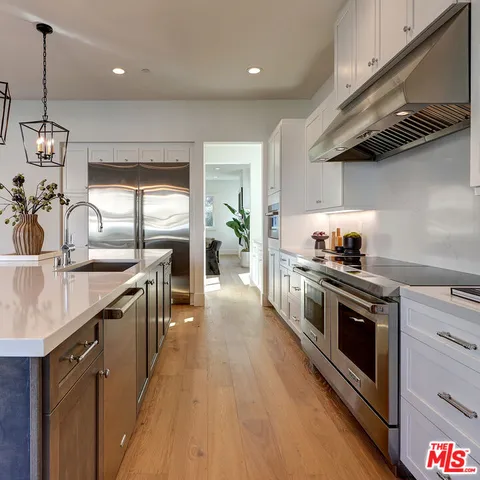 a kitchen with stainless steel appliances granite countertop a sink a stove and a wooden floors