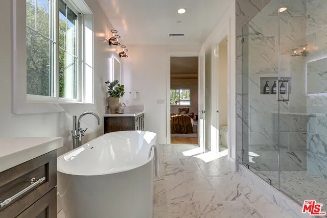 a bathroom with a sink shower and a mirror