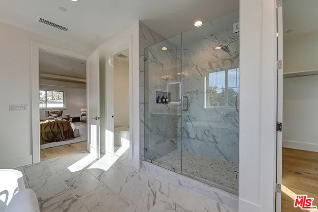 a bathroom with a glass shower door and a sink