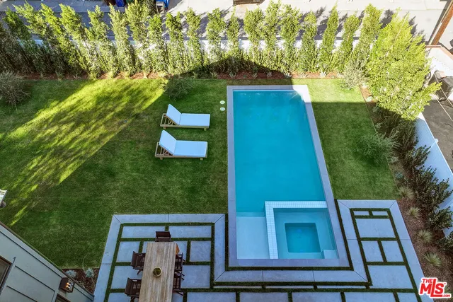 a view of a yard with plants and a bench