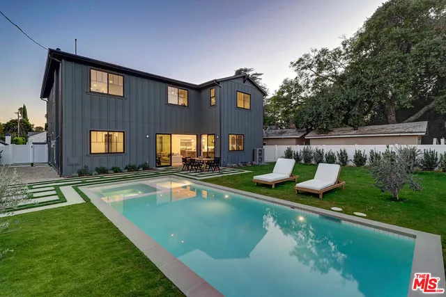 a view of a house with pool and chairs